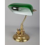 A vintage brass desk lamp featuring green glass shade.