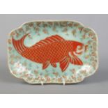 A Japanese quatrefoil shaped dish decorated with a carp on celadon background. Bearing marks in
