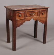 A Georgian oak side table, having three drawers and raised on square cut legs. Height 75cm, Width