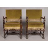 A pair of Louis XIII style carved arm chairs with velvet upholstery and carved lion mask decoration.