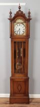 A carved oak longcase clock with turned finials. (211cm x 45cm)