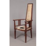 An Arts & Crafts oak arm chair. Height of back 125cm.