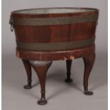 A mahogany wine cooler with twin lion mask handles and raised on four cabriole supports. Height