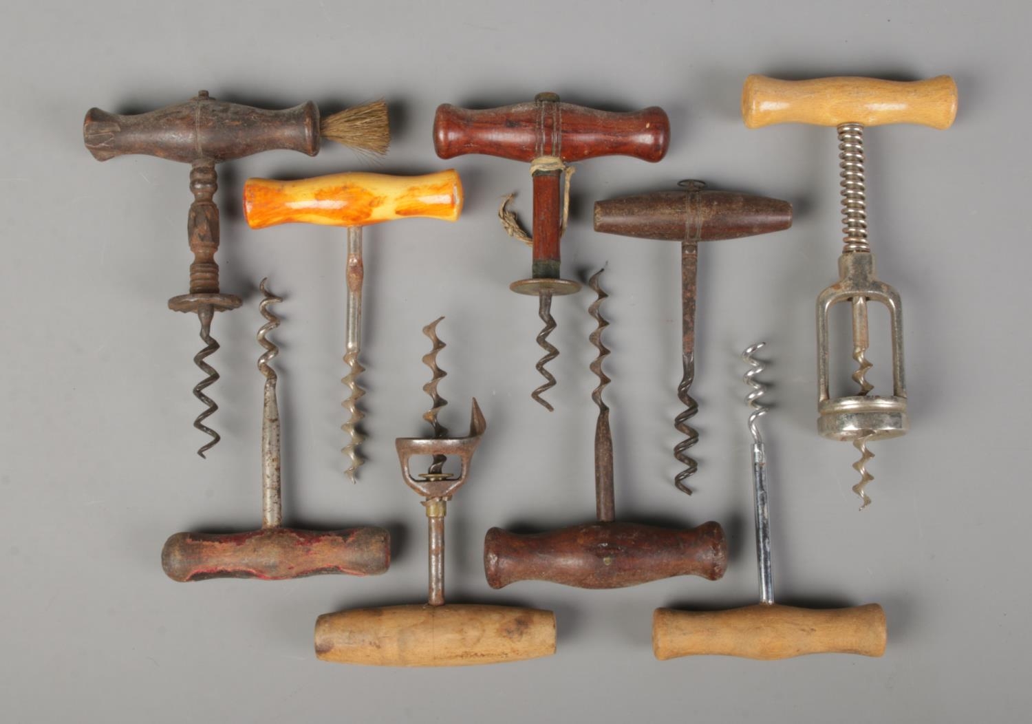 A collection of vintage and antique corkscrews. All having turned wooden handles.