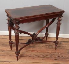 A carved mahogany fold over tea table. Raised on scrolled support and reeded tapering legs. (78cm