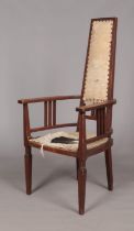 An Arts & Crafts oak arm chair. Height of back 125cm.