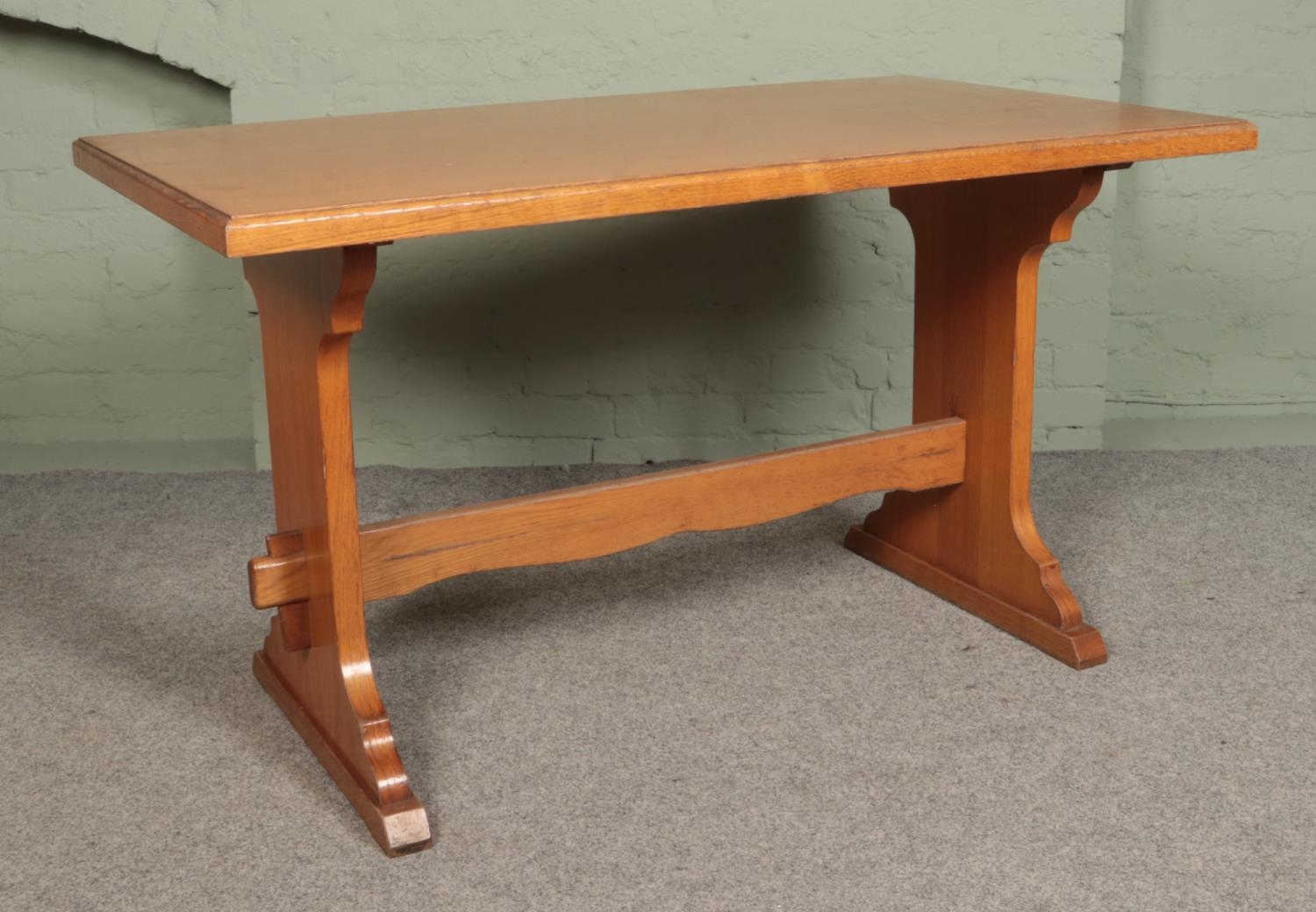 A light oak farmhouse style dining table, with central stretcher. Height: 79cm, Width: 140cm, Depth: