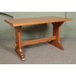 A light oak farmhouse style dining table, with central stretcher. Height: 79cm, Width: 140cm, Depth: