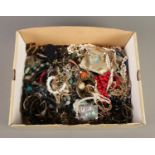 A box of costume jewellery. Includes simulated pearls, bangles, shell necklace etc.