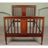 An Edwardian mahogany double bed, with iron supports, inlay panel detailing and banding to head