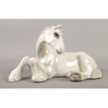 A Beswick figure modelled as a lying dapple grey shire horse. Approx. height 13cm. Tiny chip to