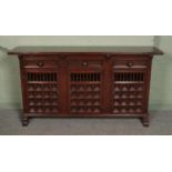A large hardwood sideboard, with drawer top and lower cupboard doors. Features spindle and paneled