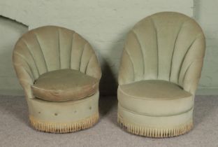 Two bedroom chairs, in sage velvet upholstery with shell back and fringed base. Both raised on