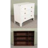A white painted three drawer chest along with an oak open bookcase.