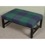 A blue & green checkered upholstered footstool.