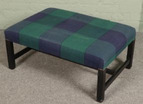 A blue & green checkered upholstered footstool.