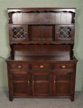 A Jaycee carved oak dresser, with glazed doors to the top and cupboard and drawer base featuring