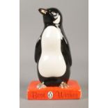 A Royal Doulton for Penguin books figure modelled as penguin standing upon a book titled 'Best