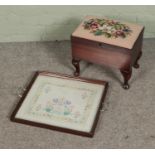 A small sewing box/footstool with contents of sewing accessories along with embroidery mounted as