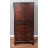 A bow fronted mahogany drinks cabinet, with cupboard doors, pull-out shelf and fake drawers to the