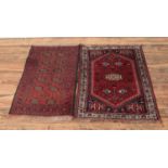 Two small red ground wool rugs featuring fringed edges and floral pattern detail. Approx. length