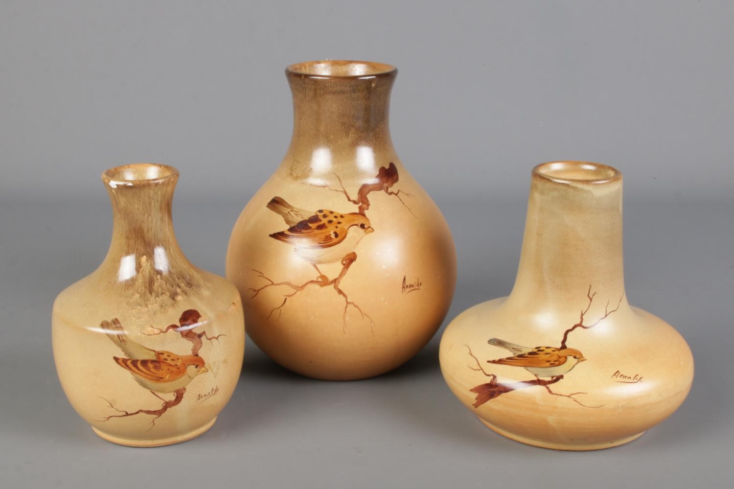 Three mid century studio pottery vases, hand painted with birds. Signed Arnaldo, possibly Arnaldo
