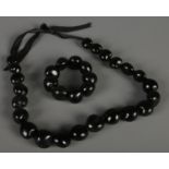 A large black bead necklace with matching bracelet.