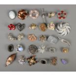 A collection of 30 costume jewellery brooches.