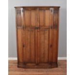 A mid 20th century oak wardrobe with linen fold carved panels made by "Crown AY Furniture" Height