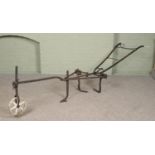 An antique iron two handle plough. Approximate length 310cm.