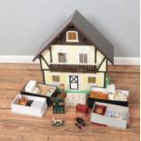 A two storey painted dolls house with four small boxes of furniture and accessories.