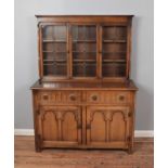 A carved oak dresser with glazed top half. Height 168cm, Width 126cm, Depth 48cm.