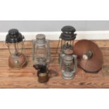 Four Tilley lamps along with a copper lined heat lamp on cast iron stand.