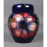 A small Moorcroft pottery dark blue ground ginger jar with cover in the 'Anemone' design. With