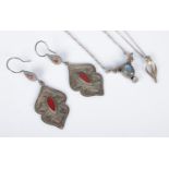 Two silver pendants on silver chain along with a pair of white metal droplet earrings.