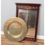A mahogany framed wall mirror with gilt decoration along with a large Eastern brass charger.