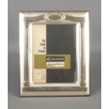 A silver photo frame, with easel back and Greek style Corinthian pillar decoration. Stamped lower