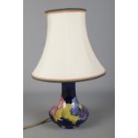 A Moorcroft blue ground Clematis pattern ceramic lamp shade. Approx. height without shade 20cm.