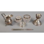 A small quantity of silver. Includes weight dwarf candlestick, napkin ring, silver cream jug, etc.