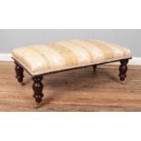 A Victorian style footstool with turned mahogany supports. Height 38cm, Width 94cm, Depth 51cm.