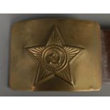 A WWII Russian brass belt buckle. Soviet red star with hammer and sickle to the centre.