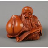 A Japanese carved Netsuke in the form of the god of longevity, signed to base.