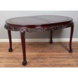 A large Chinese carved hardwood extending dining table, with three additional leaves. Featuring