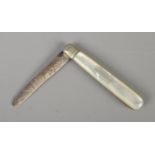 A silver bladed fruit knife featuring mother of pearl handle and ornately carved blade. Assayed