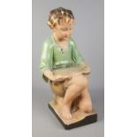 A 20th century plaster fish tank stand in the form of a kneeling boy. Approx. 34cm tall. Fish tank