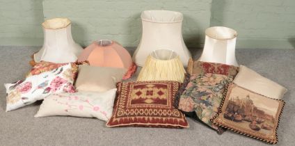 A quantity of lamp shades and pillows/cushions.