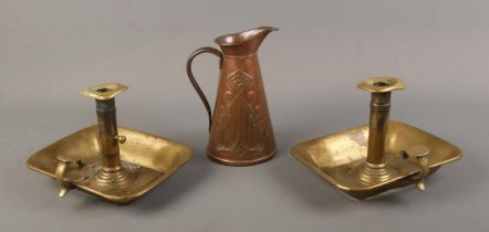 An Art Nouveau copper jug by J.S & S together with two brass chamber sticks