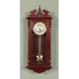 A vintage German Hermle cased wall clock featuring Roman numeral dial and Westminster chime.