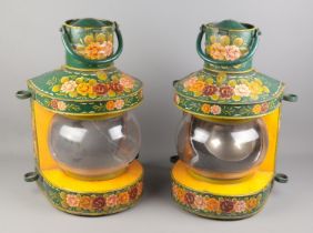 A pair of metal ships lamps with painted bargeware decoration. Approximately 49cm tall. Burners