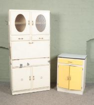 A painted utility cabinet with another smaller cabinet with enamel top.